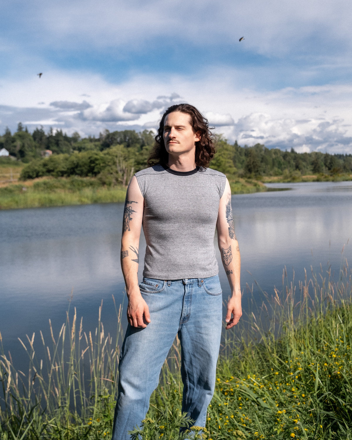 Model wearing 1990s Nino Deem contrast sleeveless top in heather gray with black trim.