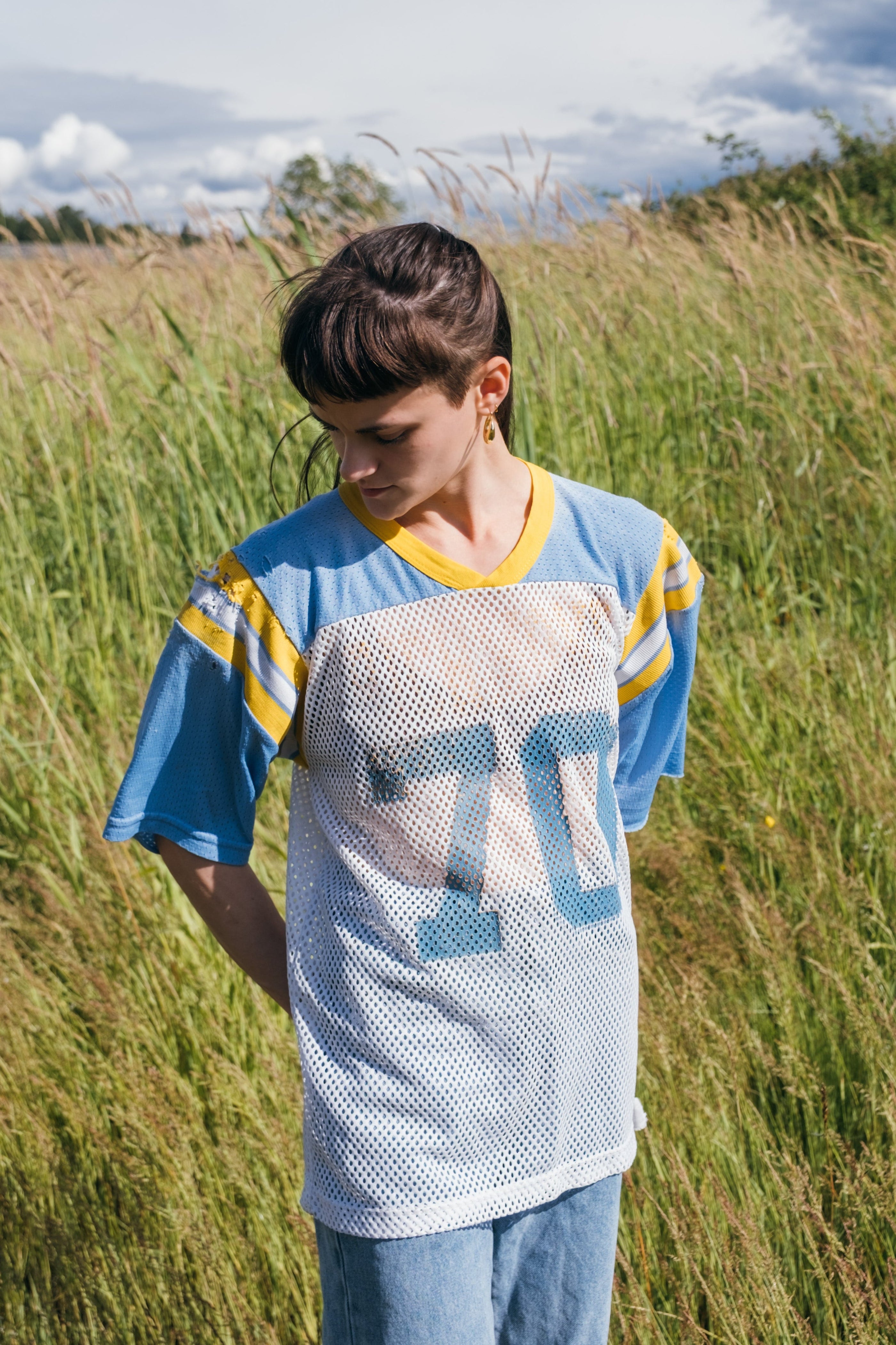 Model wearing 1980s Richmond #70 Russell Athletic football jersey in powder blue, white, and gold.
