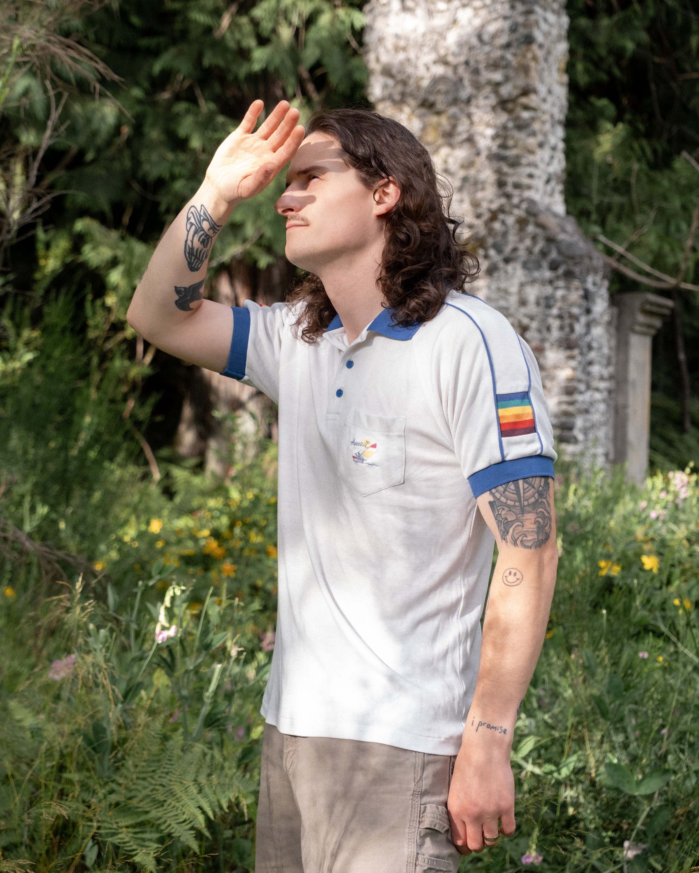 Model wearing vintage 1980s 5 Stars Hawaii rainbow sleeve polo outdoors