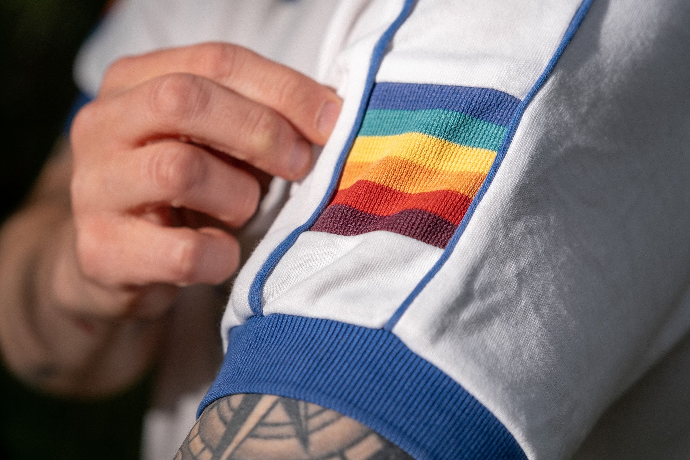 Close-up of rainbow striped sleeve panel and blue cuff on vintage 5 Stars Hawaii polo.
