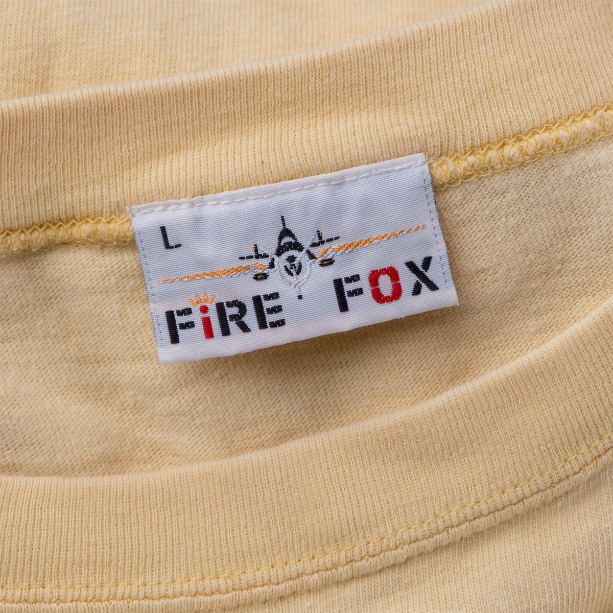 Fire Fox Large woven neck label with airplane graphic on vintage yellow sleeveless tee.