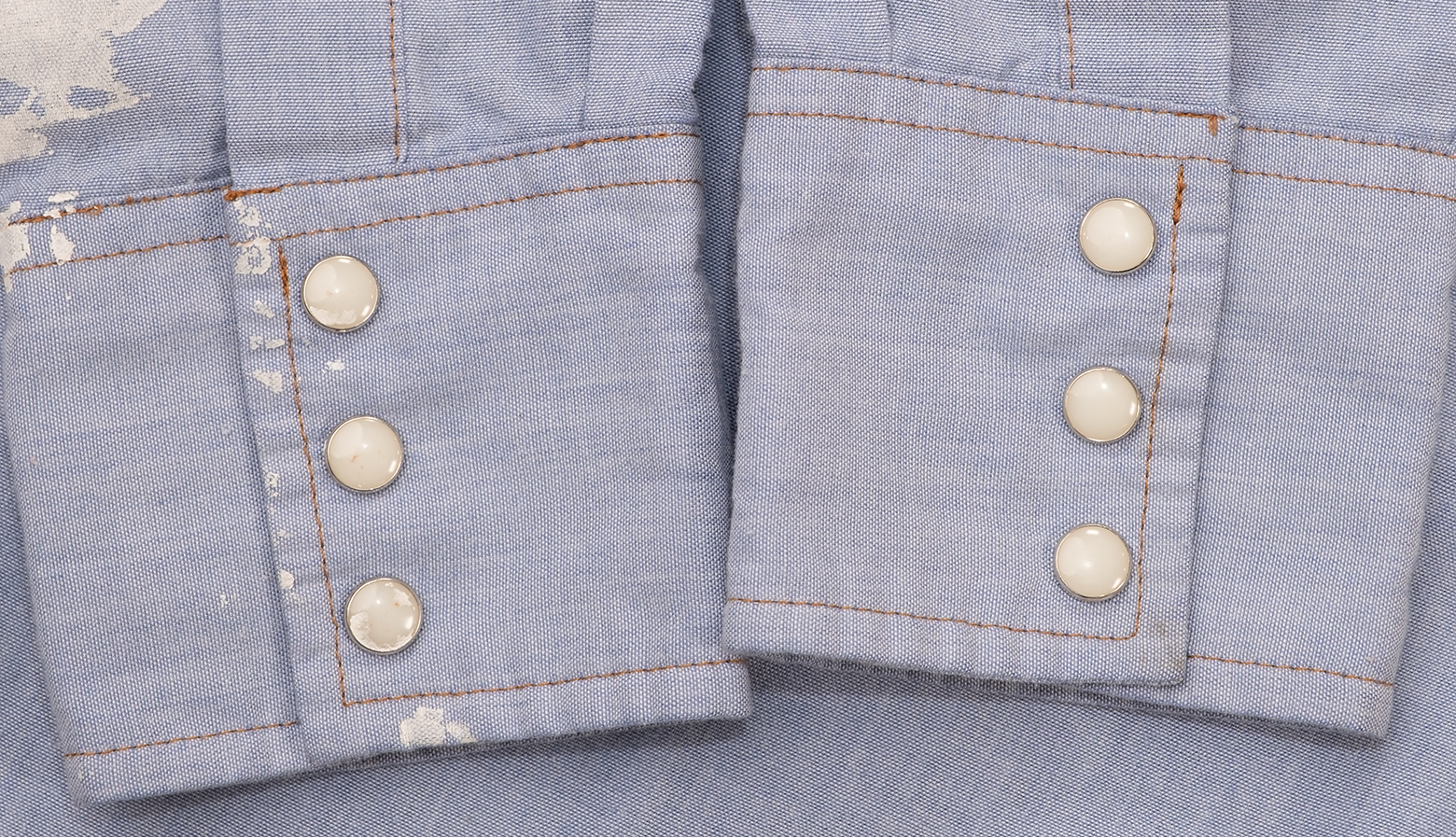 White paint marks and pearl snap cuffs on vintage Wrangler work shirt