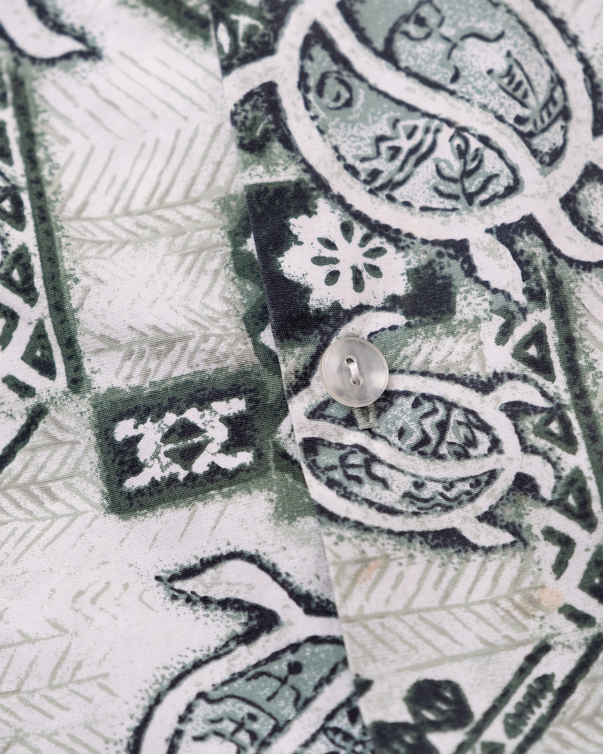 Close-up of green sea turtle and tropical foliage print on vintage Made in Hawaii aloha shirt.