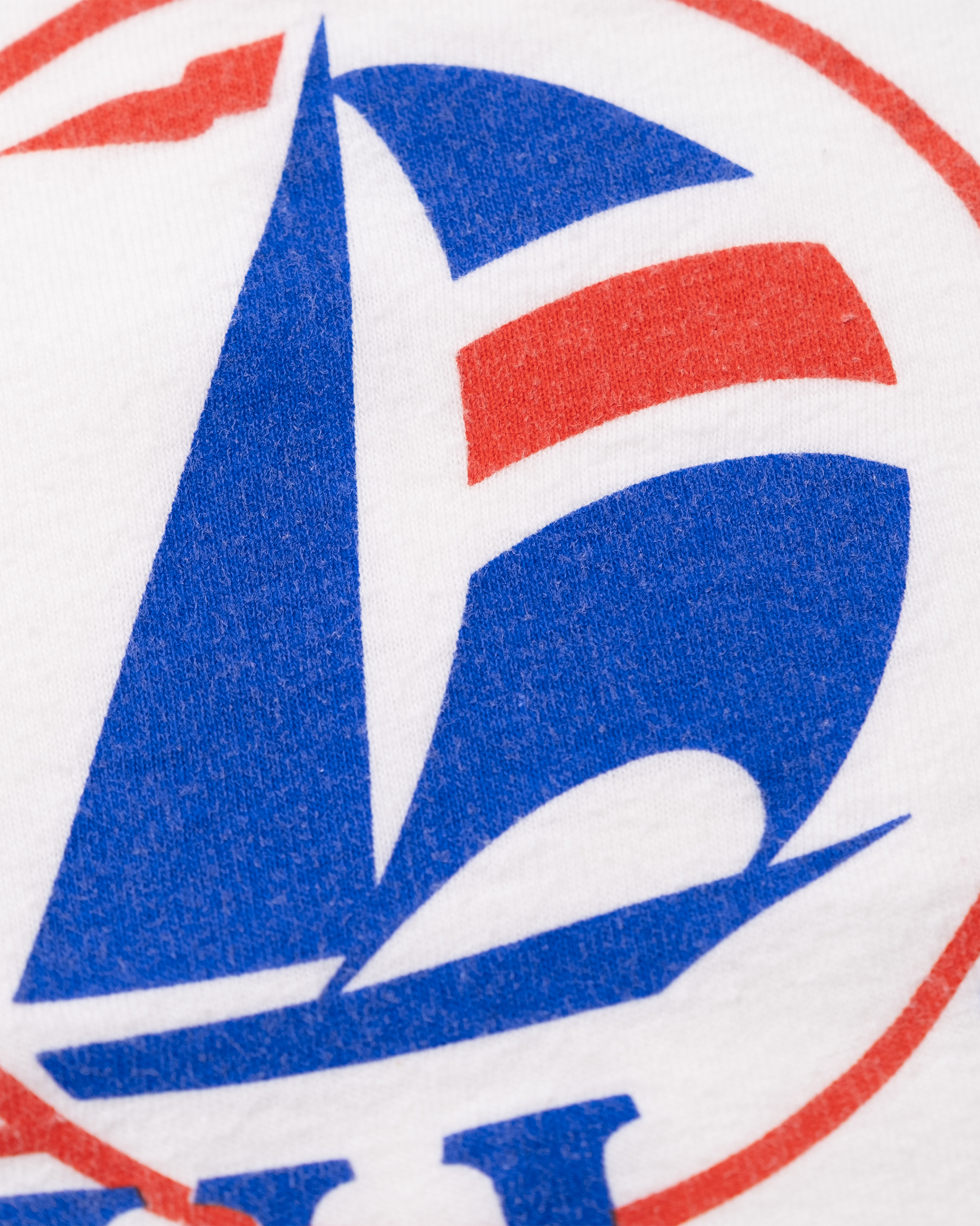 Close-up of blue and red sailboat logo on 1987 Maui Bay Yacht Club graphic tee.